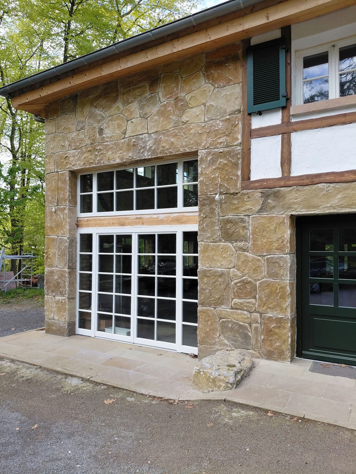 Hausfassade in Natursteinoptik neben Fachwerk