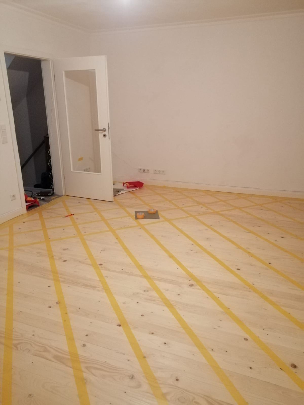 Leerer weißer Raum mit abgeklebtem Holzboden